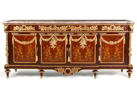 A Grand and Royal French Louis XVI style ormolu-mounted veneer and marquetry inlaid Buffet À Vantaux after the model Frédéric Durand and Sons, based on a model by Martin Carlin, Paris, Last Quarter 19th Century, The large two meter breakfront shaped eared marble top above a conforming case set with frieze drawers ornamented with swags and ribbon-tied loose bouquets pierced interlaced laurel garlands, the sides similarly decorated, Over four cupboard doors, Each door is decorated with an ormolu keyhole escutcheon and inlaid with naturalistic flowers marquetry patterns, the paneled doors hung with ormolu blossoming pendant garlands, the sides are sans traverse veneer inlaid, The angles with astonishing gilt-ormolu turned fluted colonnettes angle supports called chinoises over an arbalette shaped apron centered with an ormolu ribboned-shape blossoming floral wreath and raised on ormolu decorated six toupie feet. The luxurious buffet is a part of a dining set.